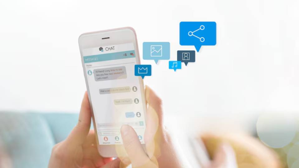A person holding a smartphone with a chat interface, displaying messages and icons for sharing images and music.